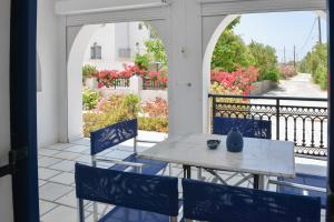 a table and chairs on a balcony with flowers at Dedalos Studios Naxos in Naxos Chora