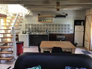 una cucina e una sala da pranzo con tavolo e scala di Coucou cottage a Saint-Congard