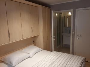a bedroom with a white bed and a cabinet at House Kimberly 194, bus 102 in Nieuwpoort