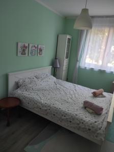 a bedroom with a bed and a table and a window at Emerald Suite in Valjevo