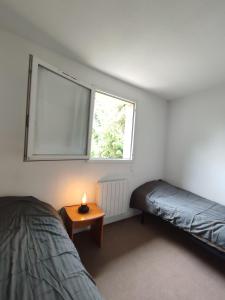 1 dormitorio con cama, mesa y ventana en Petit oasis avec piscine, en Anglet