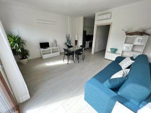 a living room with a blue couch and a table at Aviotel Residence in Marina di Campo