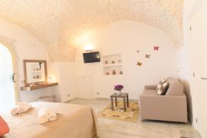 a white bedroom with a bed and a couch at LUXURY ROOM CASSESE in Ceglie Messapica