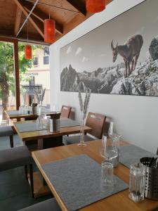 a dining room with tables and a picture of a deer on the wall at Hotel-Pension Hoferhaus in Neukirchen am Großvenediger