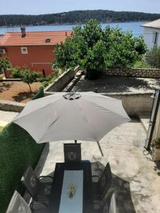 Barbat na Rabu的住宿－Holiday house Domy Rab，一张桌子上边的白色雨伞