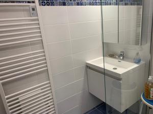 een witte badkamer met een wastafel en een spiegel bij Chambre d'hôtes Fauvart Antony Réal in Orange
