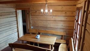 a dining room with a wooden table and chairs at Sodyba pas Juozą in Milkai