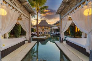 a villa with a swimming pool and a resort at Rascals Hotel - Adults Only in Kuta Lombok