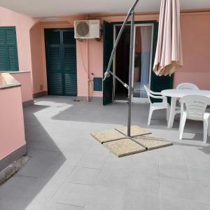 patio z parasolem, stołem i krzesłami w obiekcie Il filo di Arianna w mieście Albissola Marina