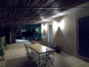 eine Terrasse mit einem Tisch und Stühlen unter der Decke in der Unterkunft Villa calme et tranquillité in Seillons-Source-dʼArgens