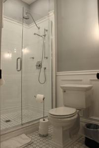 a bathroom with a toilet and a glass shower at The Plainfield Inn in Plainfield