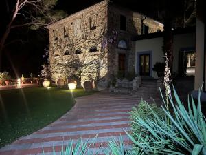 a house with a brick walkway in front of a yard at Agriturismo Bio Fattoria Bacio in Certaldo