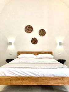 a bedroom with a bed with two plates on the wall at Dimora delle Tonnare in Favignana