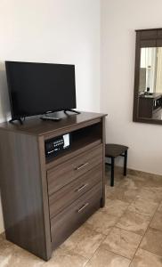 a flat screen tv on a wooden entertainment center at North Wind Motel in North Wildwood