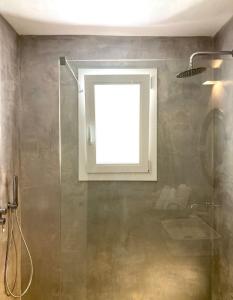 a bathroom with a shower with a window and a sink at Dimora delle Tonnare in Favignana