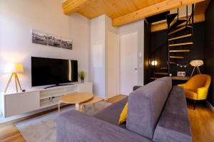 a living room with a couch and a tv at Coutinho Apartment - Modern Ap in the City Centre with Balcony in Viana do Castelo