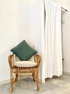 a wicker chair with a green pillow in a room at Dimora delle Tonnare in Favignana