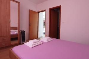 1 dormitorio con 1 cama y 3 toallas plegables. en Apartment Kristić - Saplunara, Mljet, en Babino Polje
