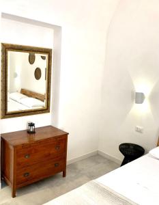 a bedroom with a dresser and a mirror at Dimora delle Tonnare in Favignana