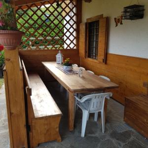 a wooden table and bench in an outdoor room at Baita Bocheto Vetriolo Levico Terme in Vetriola +10 photos