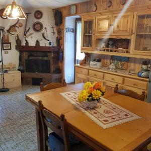 a kitchen with a wooden table with flowers on it at Baita Bocheto Vetriolo Levico Terme in Vetriola