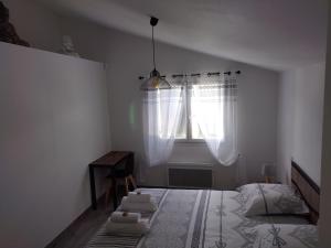 Schlafzimmer mit einem Bett und einem Fenster mit weißen Vorhängen in der Unterkunft Villa calme et tranquillité in Seillons-Source-dʼArgens