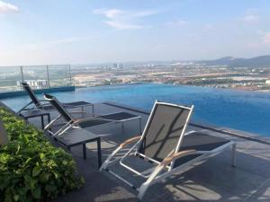 a group of chairs and a table on a roof at Sky pool 4 star hotel grade stay in i-City in Shah Alam