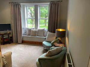 uma sala de estar com duas cadeiras e uma janela em River View em Dumfries