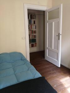 a bedroom with a blue bed and a book shelf at Camera vintage nel cuore di Monteverde in Rome