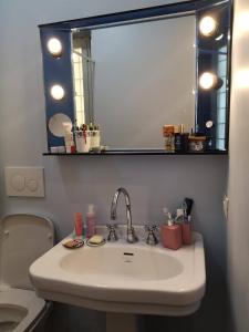 un lavandino in bagno con specchio e servizi igienici di Camera vintage nel cuore di Monteverde a Roma