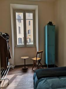 una stanza con finestra, sedia e cassettiera di Camera vintage nel cuore di Monteverde a Roma