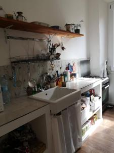 a kitchen with a sink and an open refrigerator at Camera vintage nel cuore di Monteverde in Rome