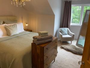 1 dormitorio con cama, silla y espejo en River View en Dumfries