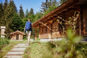 a woman with a backpack walking past a building at Chalet-karwendel in Terfens