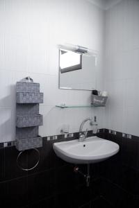 a bathroom with a white sink and a mirror at Guesthouse Gaby in Sapareva Banya