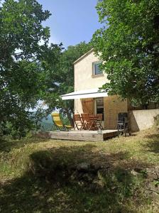 une maison avec des chaises assises sur une terrasse dans la cour dans l'établissement Maison 38m2 15min de Corte 30min de Bastia, à Bigorno