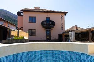 a house with a swimming pool in front of a building at Guesthouse Gaby in Sapareva Banya
