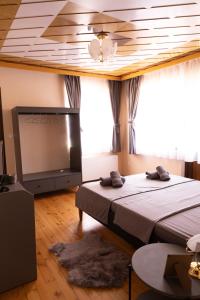 a bedroom with a bed and a flat screen tv at Guesthouse Gaby in Sapareva Banya
