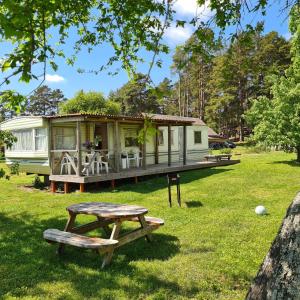 a tiny caravan in a park with a picnic table at Rožu 20 in Mērsrags