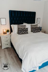 een slaapkamer met een groot bed met een blauw hoofdeinde bij Stylish Belfast City Centre 2 Bedroom Apt Free Parking in Belfast