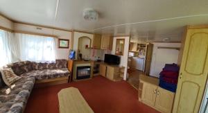 a living room with a couch and a kitchen at Rožu 20 in Mērsrags +10 photos