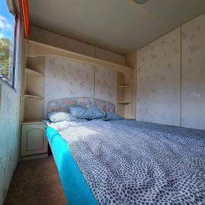 a bedroom with a bed with a blue and white comforter at Rožu 20 in Mērsrags