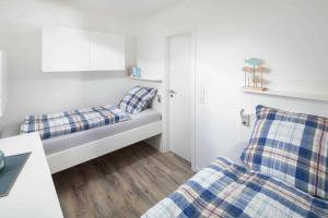 Habitación pequeña con 2 camas y mesa. en Anker 03 en Norderney