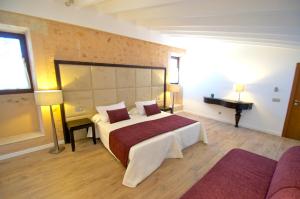 una habitación de hotel con una cama grande y un piano en Bennoc Petit Hotel, en Llucmajor