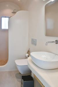 uma casa de banho branca com um WC e um lavatório em Dedalos Studios Naxos em Naxos Chora
