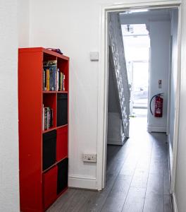 a red book shelf in a hallway next to a door at 33 Turner street in Redcar
