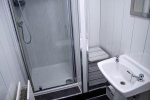 a white bathroom with a shower and a sink at 33 Turner street in Redcar