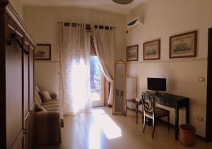 sala de estar con sofá, TV y ventana en B&B Borgomarino, en Pescara