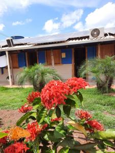 a house with red flowers in front of it at Agência e Pousada Estância da Mata in Estivado