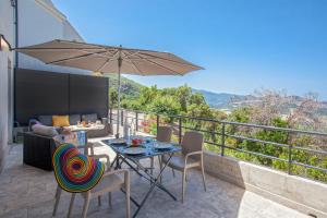 un patio con mesa, sillas y sombrilla en Cote Nebbiu en Barbaggio